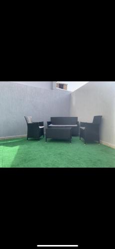 sala de estar con 2 sofás y suelo verde en Jolie appartement avec terrasse, en Casablanca