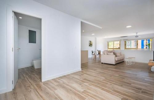 a living room with white walls and wooden floors at Vive la Vila cozy apartment by the beach in Villajoyosa