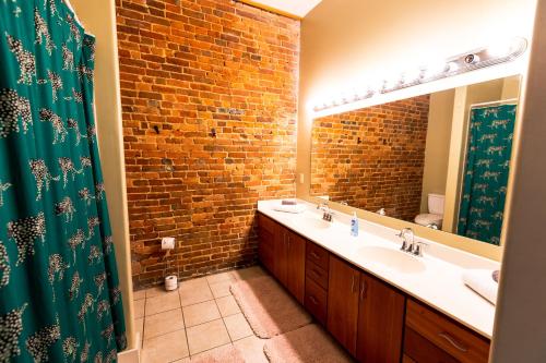 a bathroom with two sinks and a brick wall at The Boho Loft in Springfield