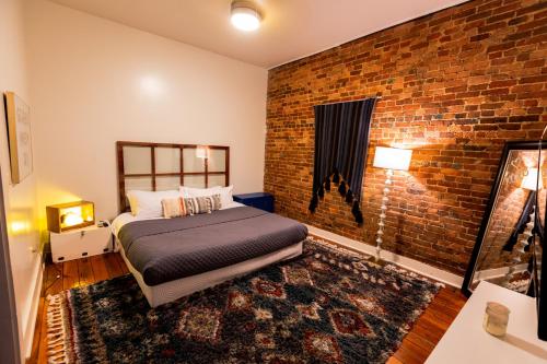 a bedroom with a bed and a brick wall at The Boho Loft in Springfield