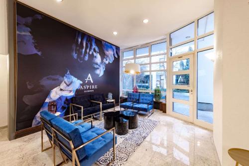 a room with blue chairs and a wall with a movie poster at Aspire Elements Reutlingen, Trademark Collection by Wyndham in Reutlingen