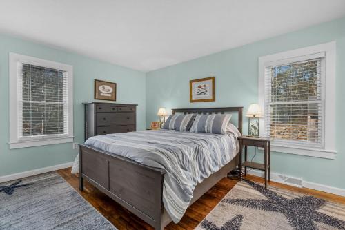 a bedroom with a bed and two windows at 14 Quail Nest Run Harwich Cape Cod - Hawksnest Hideaway in Harwich