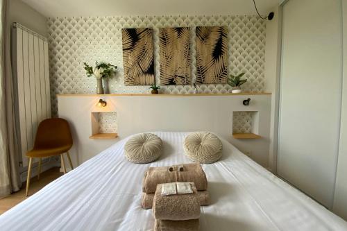 - une chambre avec un lit blanc et des serviettes dans l'établissement Aesthetics - 2 bedrooms and secure parking!, à Montpellier