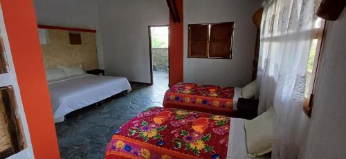 a bedroom with two beds and a window and a room with two beds at finca hotel palmas frente a panaca in Quimbaya