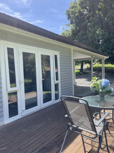 a patio with a table and chairs on a deck at Guest Wing in Richmond Downs in Walton