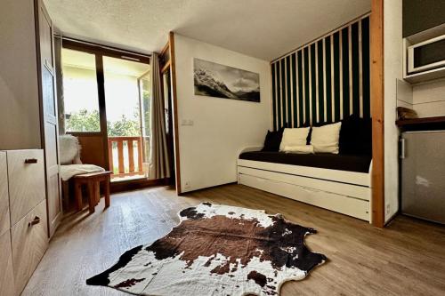Habitación con cama y alfombra en el suelo en The Edelweiss- Renovated studio for 4 people! en Chamrousse