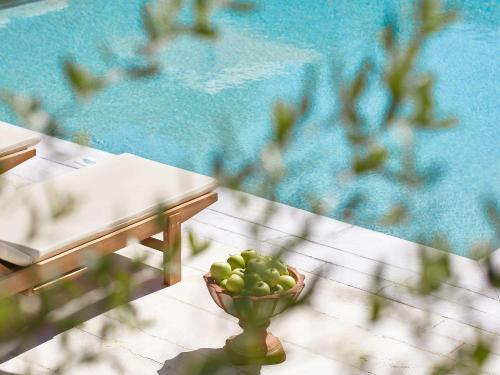 un tazón de manzanas verdes sentado junto a una piscina en Villa Oliva, en Adelianos Kampos