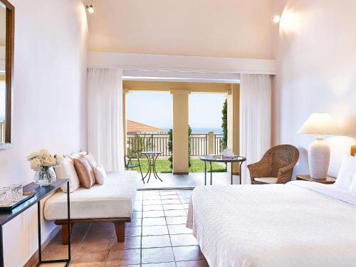 ein Hotelzimmer mit einem Bett und einem Balkon in der Unterkunft Grecotel Olympia Oasis & Aqua Park in Loutra Killinis