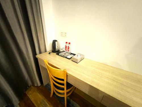 a wooden table with a telephone and a chair at Fusion Hotel in Sihanoukville