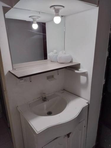 a white bathroom with a sink and a mirror at comodidad y ubicación. in Medellín