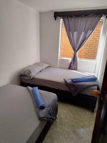 two beds in a room with a window at comodidad y ubicación. in Medellín