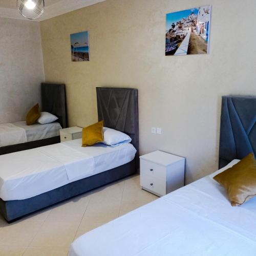 Habitación con 2 camas y una foto en la pared. en Luxury Apartement in City Center F2 en Tánger