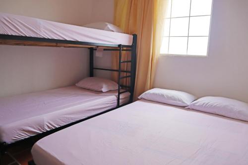 2 łóżka piętrowe w pokoju z oknem w obiekcie Villa Bonita w mieście Bucaramanga