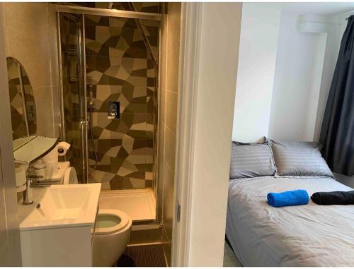 baño pequeño con cama y ducha en Central London property-ensuite, double and budget room en Londres