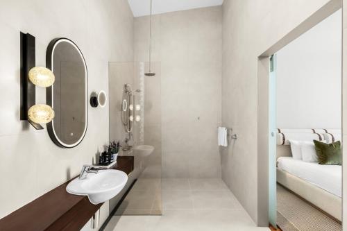 Un baño blanco con lavabo y espejo. en The Longhouse - Suite 1, en Pokolbin