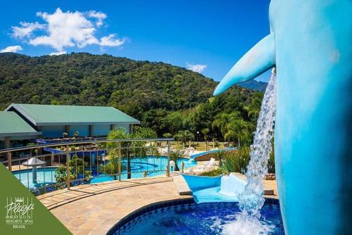 a dolphin fountain in front of a swimming pool at Apartamento completo resort in Represa Capivari