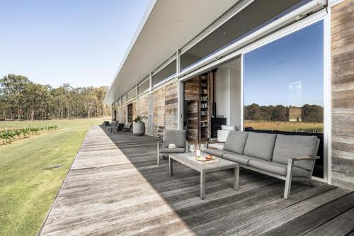 an outdoor patio with a couch and a table at The Longhouse - Suite 2 in Pokolbin