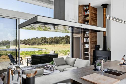 a kitchen and living room with a fireplace and a couch at The Longhouse - Suite 2 in Pokolbin