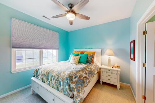 a blue bedroom with a bed and a ceiling fan at White Creek at Bethany --- 30930 Sea Breeze Ln in Ocean View