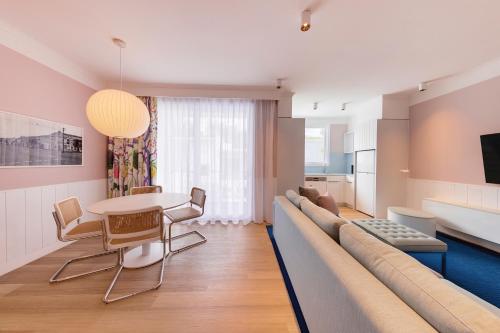 a living room with a couch and a table and chairs at Adina Apartment Hotel Chippendale in Sydney