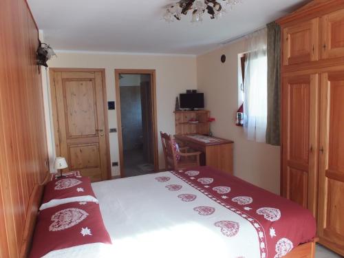 a bedroom with a bed with a red and white blanket at Maison Gaudenzio in Challand Saint Anselme