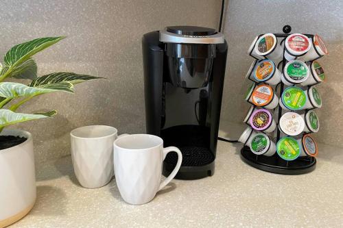 a coffee maker and two cups on a counter at Chico Creek House - Hot Tub, Game Room & Fire Pit in Chico