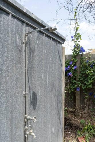 a shower is attached to the side of a wall at Shoreline Sanctuary - A Retro Family Beach Shack in Somers