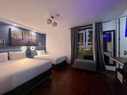 een hotelkamer met 2 bedden en een raam bij La Casa del Viajero in Lima