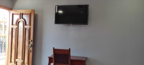 uma televisão de ecrã plano pendurada numa parede em HOSTAL RIVAS INNS em Rivas