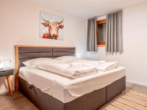 1 cama en un dormitorio con una foto de vaca en la pared en Selbhorn, en Hinterthal