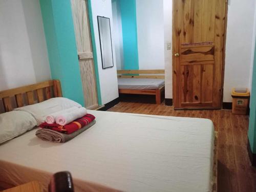 a bedroom with a bed with two towels on it at Pas-it Hostel Sagada in Sagada