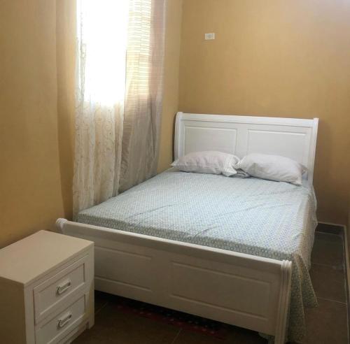 a small bed with two pillows and a window at La hermosa hotel in Santa Cruz de Barahona