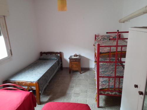 a room with two bunk beds and a table at Alquiler de Casa en Cosquin temporario in Cosquín