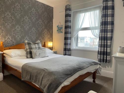 a bed in a room with a window and a bed sidx sidx sidx at Bella Vista in Paignton