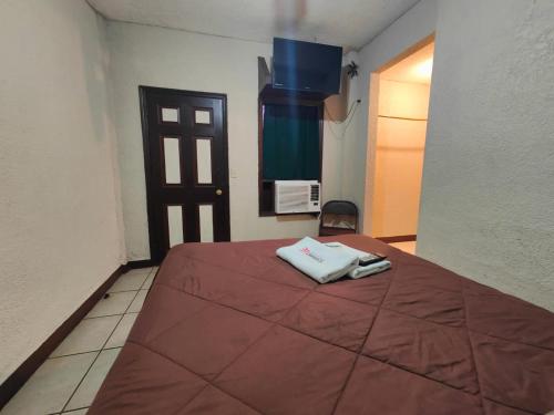 Habitación de hotel con cama con manta roja en Hotel Chinesca en Mexicali