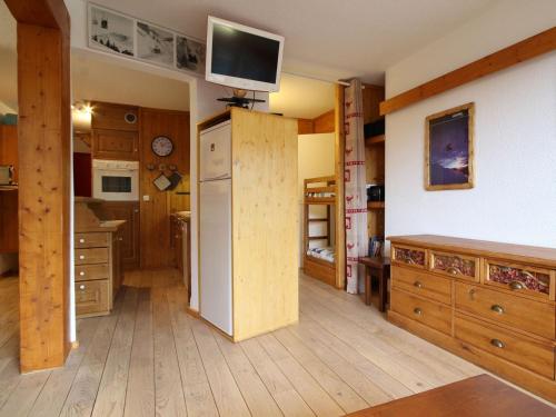 Il comprend une cuisine équipée d'un réfrigérateur et une télévision murale. dans l'établissement Appartement Rénové au Centre, Balcon Sud-Ouest, Wifi Gratuit, Proche Pistes et Commerces - FR-1-346-319, à Arc 1800