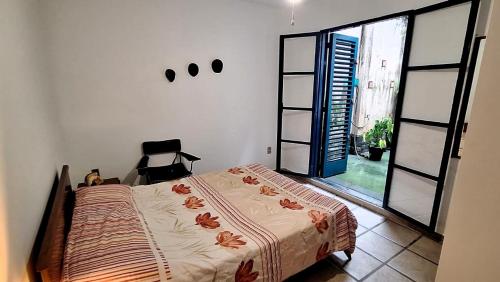 a bedroom with a bed and a large window at Recanto das tartarugas in Mangaratiba
