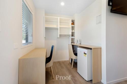 a small kitchen with a table and a refrigerator at Waiheke Island Resort Conference & Accomodation Centre in Ostend