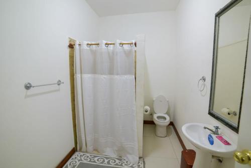 uma casa de banho com um chuveiro, um WC e um lavatório. em HOSTAL RIVAS INNS em Rivas