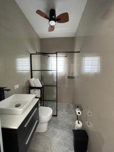 a bathroom with a toilet and a ceiling fan at El Balcón de Luly in Culebra