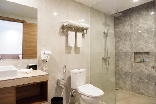 a bathroom with a shower and a toilet and a sink at ASTON Inn Pandanaran in Semarang