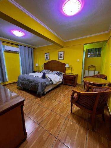 Hotel Thesalia في سانتياغو: غرفة نوم بسرير وطاولة وكراسي