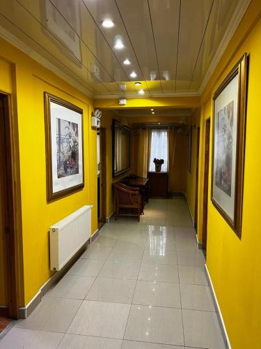 Hotel Thesalia في سانتياغو: ممر بجدران صفراء وبيانو في الغرفة