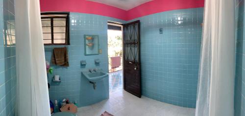 baño con paredes de azulejos azules y lavabo en LAM Casa Hostal en San Cristóbal de Las Casas
