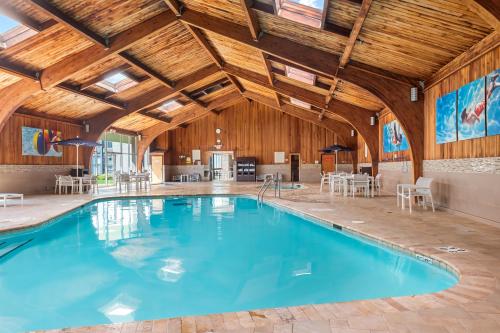 a swimming pool in a large room with wooden ceilings at DoubleTree by Hilton Roseville Minneapolis in Roseville