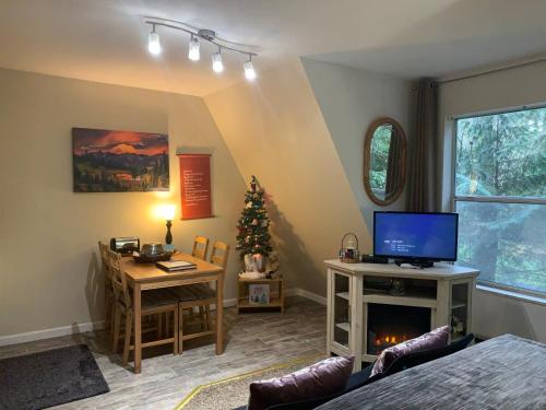 a living room with a christmas tree and a television at Mountain Meadows Inn & Chalet Suites in Ashford