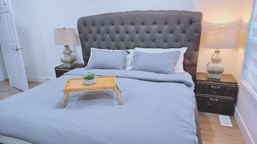 Un dormitorio con una cama con una mesa. en Private King Room - Shared Washroom - 5 min to Surrey Fleetwood en Surrey