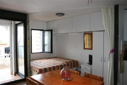 - une chambre avec un lit et une table en bois dans l'établissement Résidence Grenada - Appartement T2 Cabine 5 couchages LE BARCARES MAE-7954, au Barcarès