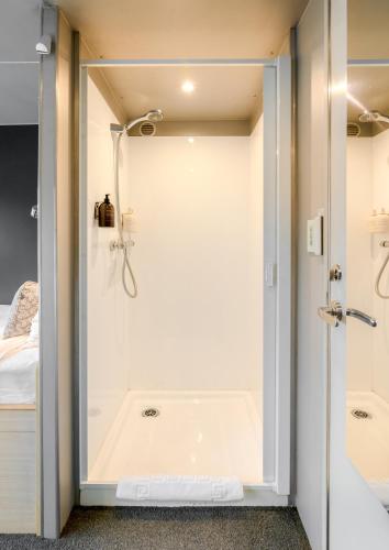 a bathroom with a shower with a glass door at Milford Sound Overnight Cruise - Fiordland Discovery in Milford Sound