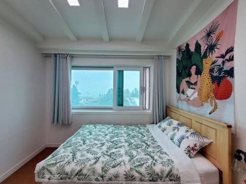 濟州的住宿－Aewol Gwangryeong House，一间卧室设有一张床和一个大窗户